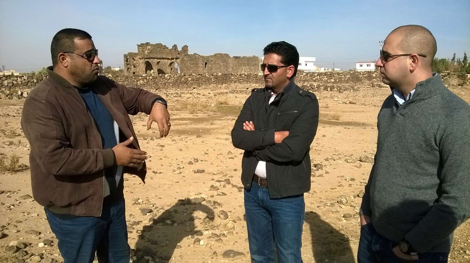 Umm al-Jimal Project team member Muaffaq al-Hazza (left) discusses the history of the site with SCHEP team members Abdelrahman al-Nasarat (center) and Ragheb Fityan (right). SCHEP makes regular visits to partner sites throughout Jordan to assess needs and community involvement. Photo by Glenn J. Corbett.