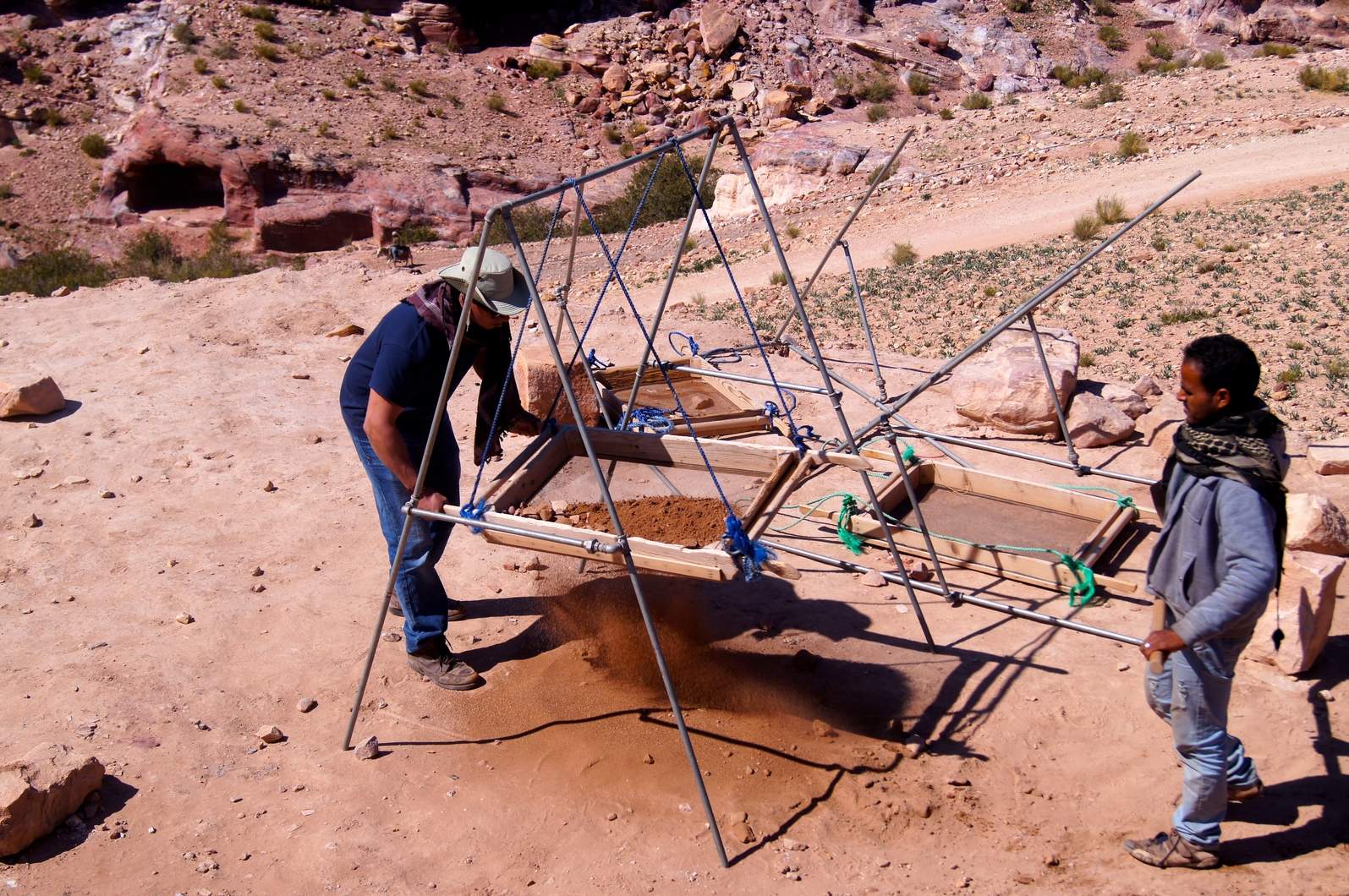 While on site, Gregory and Thomas were able to take part in many of the landscape rehabilitation activities currently being undertaken by the project. Here, Gregory (left), with guidance from team member Bassam Faqeer (right), sifts dirt removed from Soil Dump 4 while looking for pottery and other artifacts. Photo by Thomas Harr.