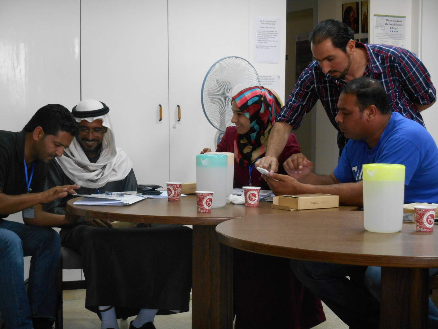 SCHEP site stewards Mohammad al-Saideen (left), Safa’ al-Rfooh (center), and Bilal al-Deghemat (right) learn how to use their new Samsung digital tablets with the assistance of workshop co-organizer Abdelrahman al-Nasarat (far left) and ACOR IT consultant Ashraf al-Darawish (far right). Photo by Wiebke Lepke.